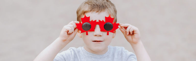 Boy wearing sunglasses against wall