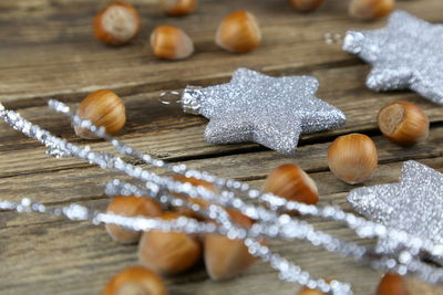 Close-up of star shape decorations with chestnuts on wooden table