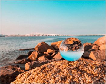 Close-up of rocks on beach against clear sky