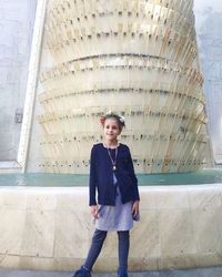 Smiling girl standing glass fountain