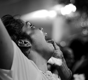 Cropped hand piercing needles in woman tongue during thaipusam