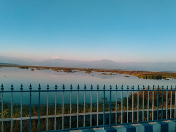 Scenic view of lake against clear blue sky