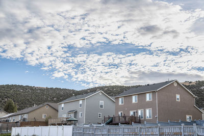 Houses and buildings in town against sky