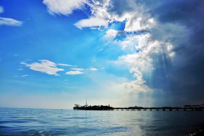 Boats in sea against cloudy sky