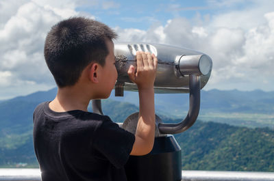 Rear view of boy looking at camera