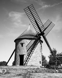 Traditional windmill on field against sky