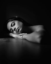 Portrait of young woman lying on table