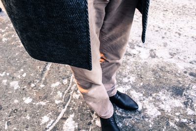 Low section of man standing on road