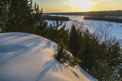 Scenic view of snow covered landscape against sky during sunset