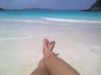 Low section of person relaxing on beach