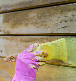 Close-up of hand painting wood with brush