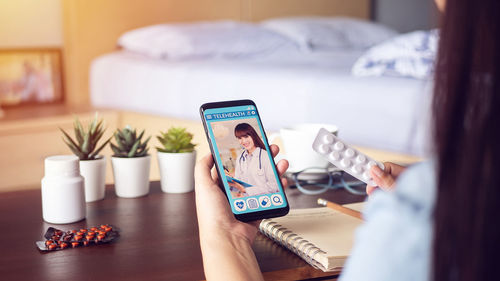 Woman using mobile phone on bed