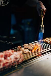 Person preparing food on barbecue grill