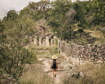Rear view of woman walking on field
