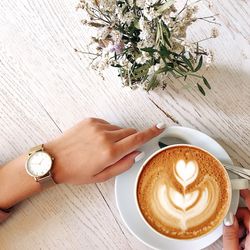 High angle view of woman with coffee on table