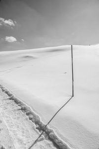 Snow covered land against sky