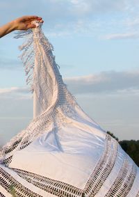 Midsection of woman holding umbrella against sky