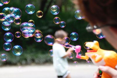 Boy playing with bubbles outdoors