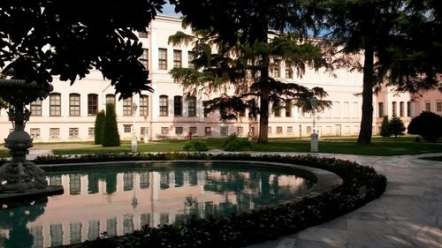 Reflection of building on swimming pool in pond