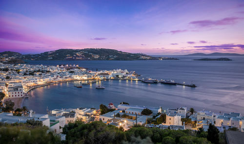 Scenic view of townscape by sea at mykonos during sunset