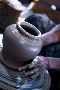 Midsection of man working on pottery wheel