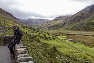 Side view of man standing on landscape against sky