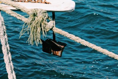 High angle view of rope tied on wooden post in sea