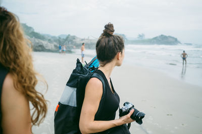 Woman standing on beach against sky