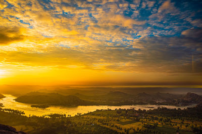 A sunrise view from anjanadri temple hill top in the morning of tungabadra river glittering in sun