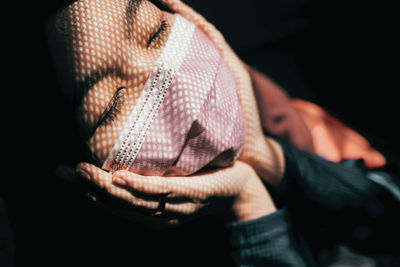 Young woman wearing mask in darkroom