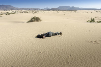 High angle view of woman lying on sand