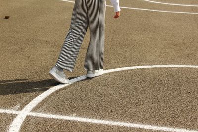 Low section of woman walking on playing field