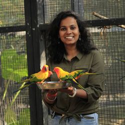 Portrait of smiling young woman holding plate with birds