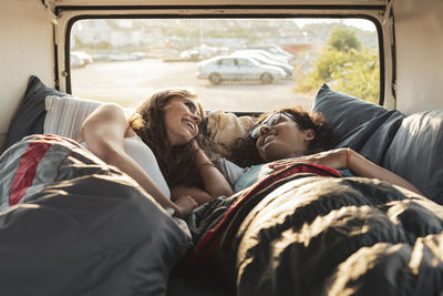Young couple relaxing while lying in van