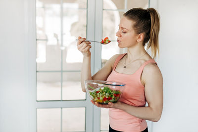 Portrait of an attractive woman holding a salad bowl and looking at the camera. beautiful athletic 