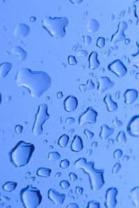 Full frame shot of water drops on blue surface