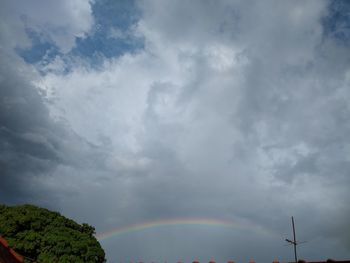Low angle view of rainbow against cloudy sky