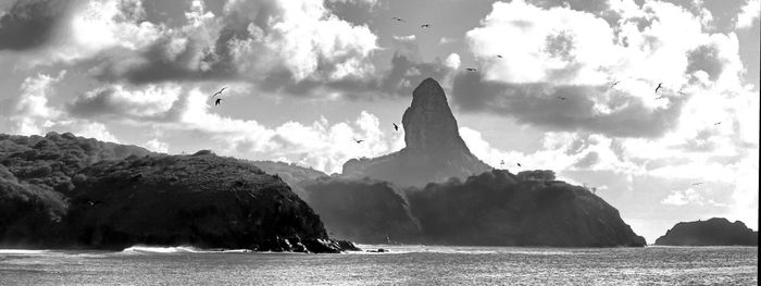 Panoramic view of sea and mountains against sky