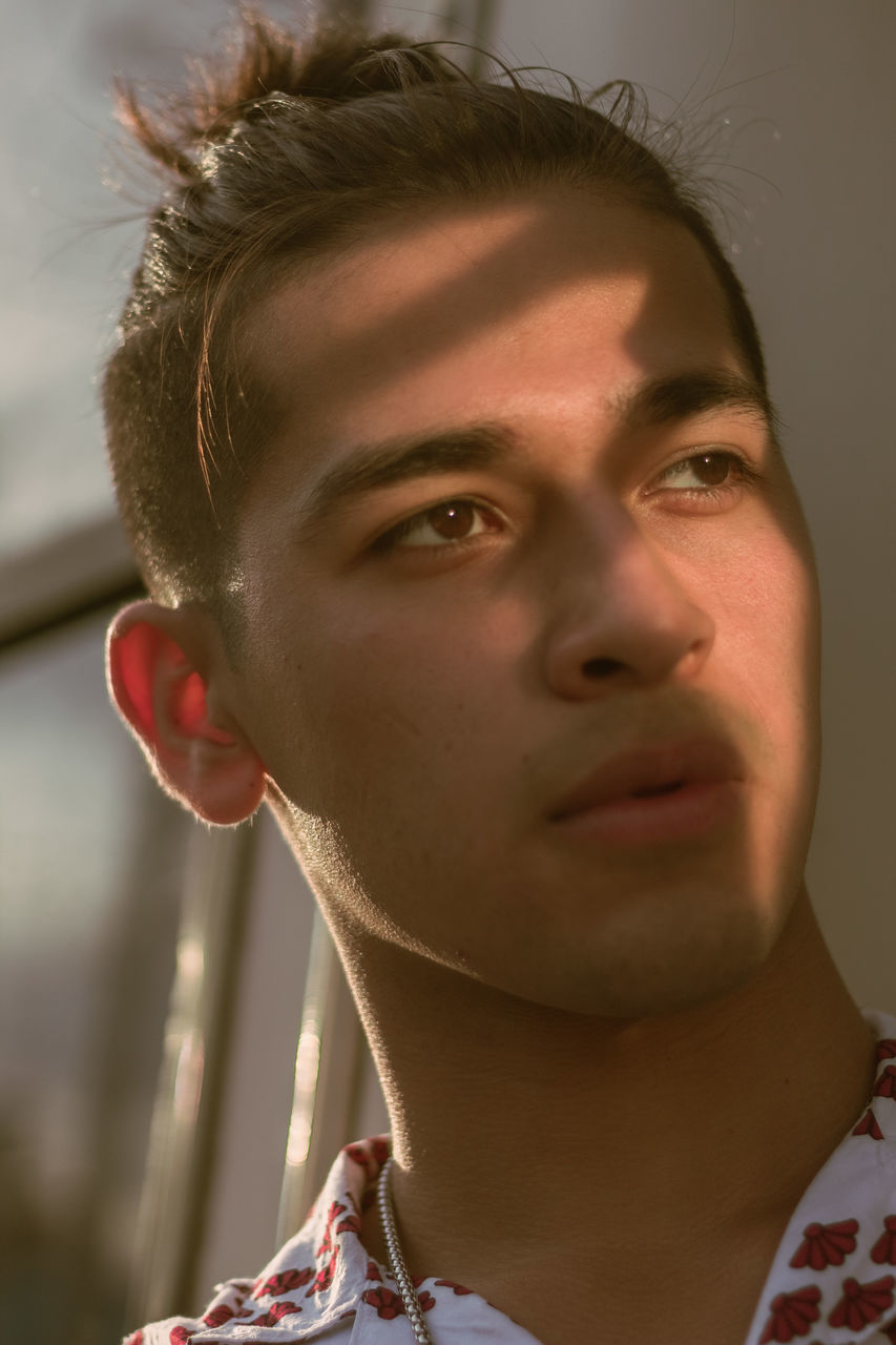 headshot, portrait, one person, close-up, real people, young adult, front view, looking, lifestyles, leisure activity, looking away, focus on foreground, indoors, serious, young men, contemplation, body part, human body part, human face, teenager