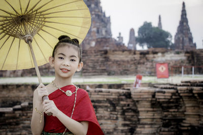 Portrait of boy standing against built structure