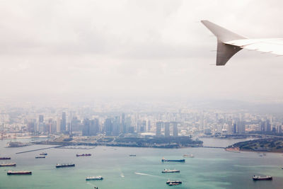 Aerial view of sea and buildings against sky