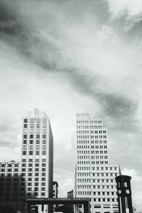 Low angle view of modern building against cloudy sky