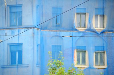 Exterior of old building covered with blue net