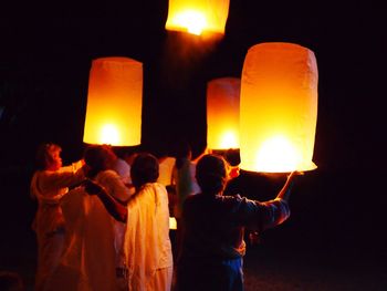 Rear view of people at night