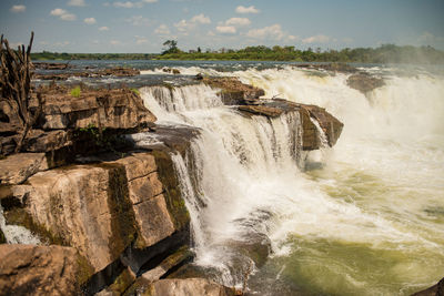 Scenic view of waterfall against sky