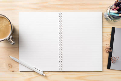 Directly above shot of open spiral notebook and pen on table