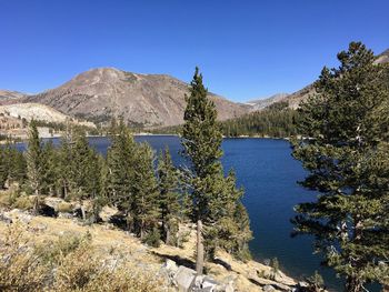 Scenic view of lake and mountains against clear blue sky