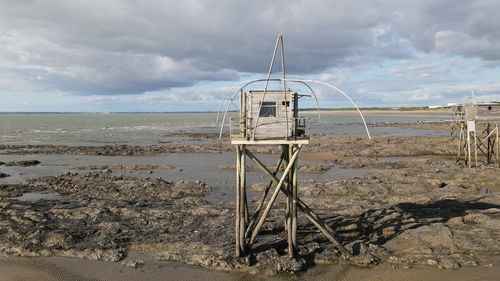 Lifeguard hut on beach against sky