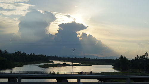 Scenic view of river against cloudy sky