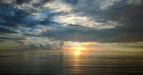 Scenic view of sea against dramatic sky during sunset